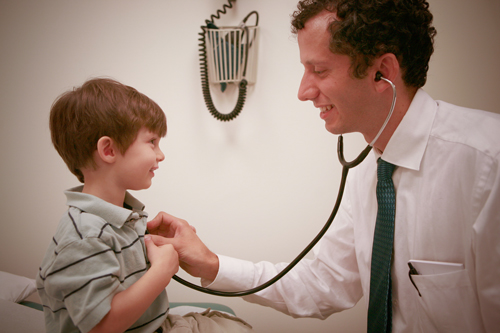 doctor holding stethescope to child
